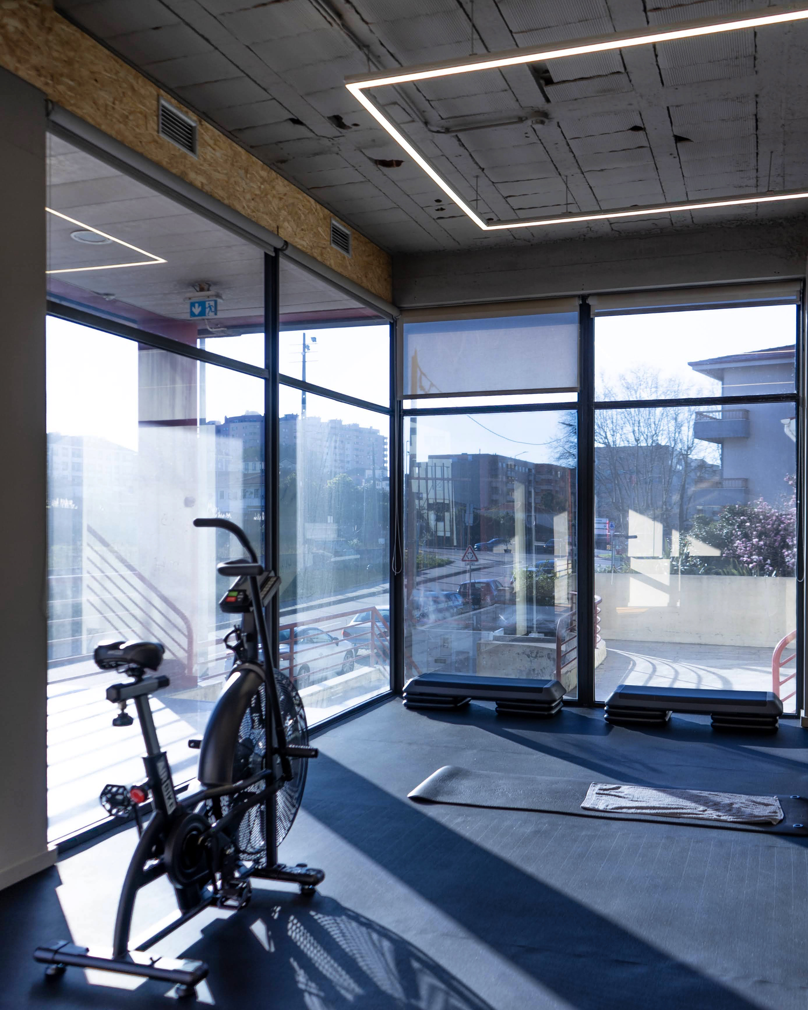 Zona de cardio e luz natural com AirBike